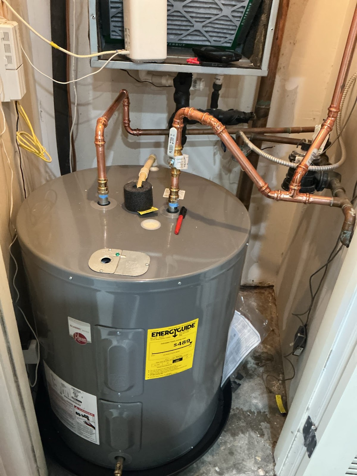 PlumbingPro North Atlanta — freshly installed Rheem electric water heater with new copper supply loops and expansion connections